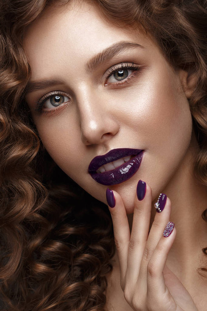 Beautiful girl with evening make-up, purple lips, curls and design manicure nails. beauty face. - Foto, afbeelding