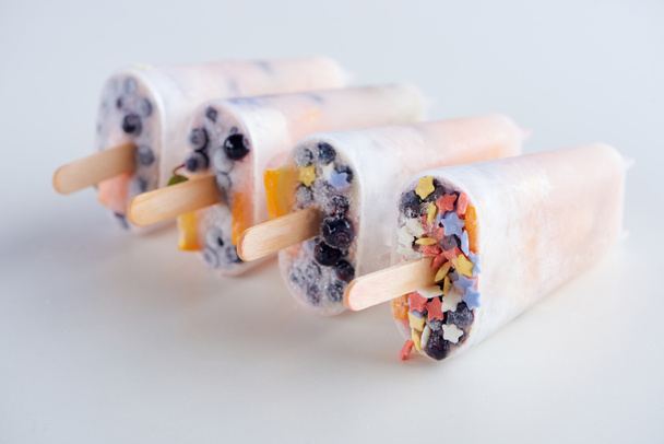 close-up view of fresh frozen homemade popsicles with fruits and berries on grey - Zdjęcie, obraz