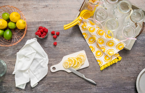 Limonada de frambuesa adornada con limón fresco y frambuesas en frascos de albañil para beber
. - Foto, Imagen