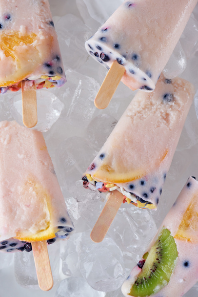 close-up view of gourmet homemade popsicles with fruits and berries on ice cubes   - Zdjęcie, obraz