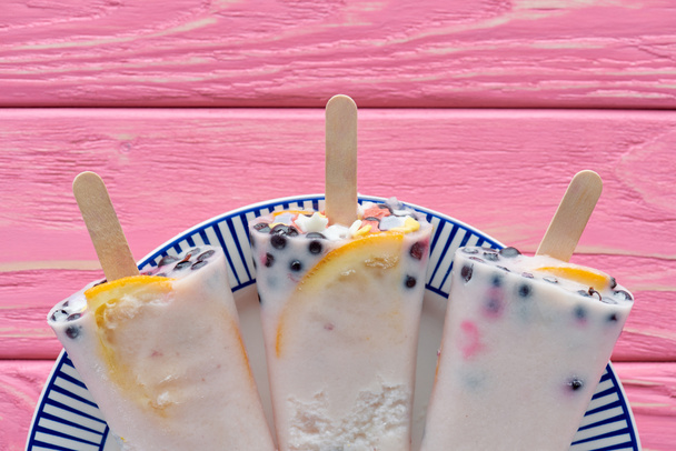 vue du dessus de la crème glacée maison sucrée savoureuse avec des fruits et des baies sur une assiette sur une table en bois rose
   - Photo, image