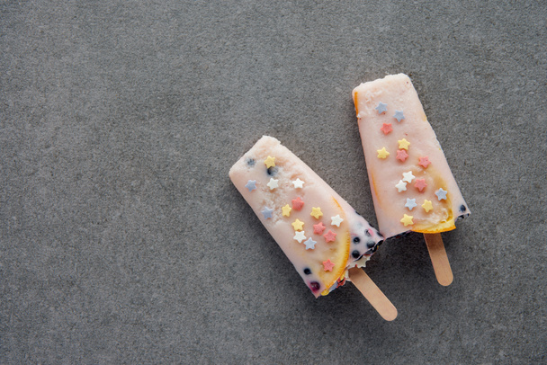 top view of delicious cold popsicles on sticks on grey background  - Photo, Image