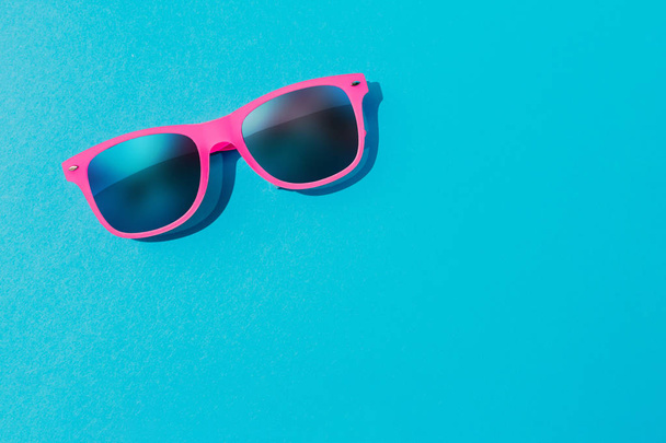 Pink sunglasses on pastel blue background, Minimal summer concept  - Fotoğraf, Görsel
