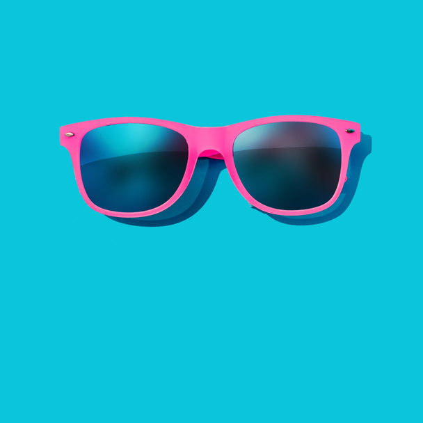 Roze zonnebril op pastel blauwe achtergrond, minimale zomer concept  - Foto, afbeelding