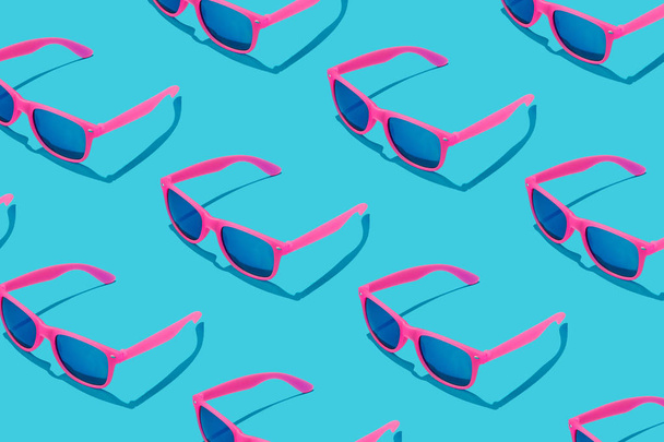 Рожевий візерунок сонцезахисних окулярів на пастельному синьому фоні, концепція мінімального літа
  - Фото, зображення