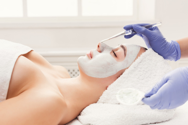 Woman gets face mask by beautician at spa - Zdjęcie, obraz