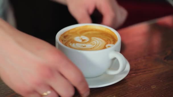 Barista makes a drawing on coffee. Art of making cappuccino in a cup. - Filmati, video
