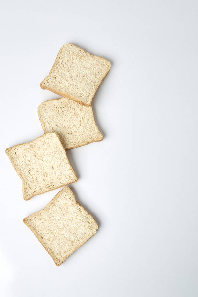 白い背景上に分離されて全体の小麦のパンのスライス - 写真・画像