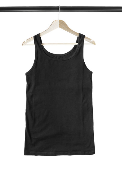 Black basic sport tank top hanging on wooden clothes rack isolated over white - Foto, immagini
