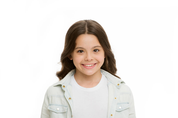 Brilliant smile. Child charming white smile isolated white background. Kid girl long curly hair cheerful happy. Girl curly hairstyle adorable smiling face. Kid happy carefree enjoy childhood - Fotografie, Obrázek