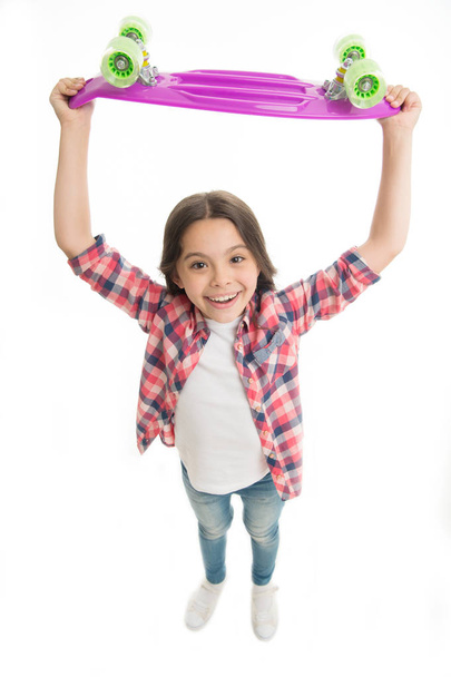 Best gift ever. Kid girl happy raising penny board. Child likes plastic skateboard as gift. Modern teen hobby. How to ride penny board. Girl happy face carries penny board above head white background - Photo, Image