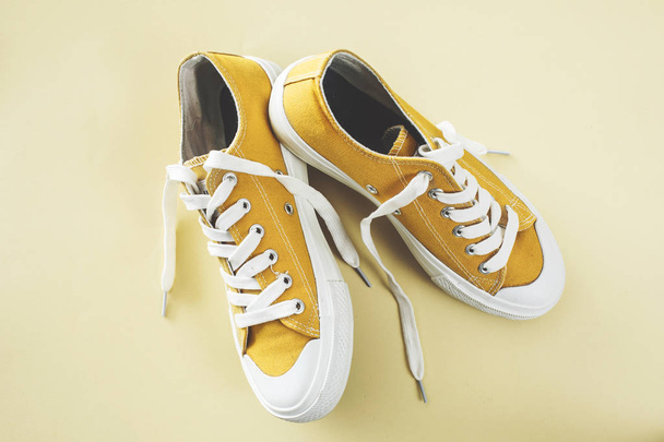 Жовте спортивне взуття на жовтому тлі
 - Фото, зображення