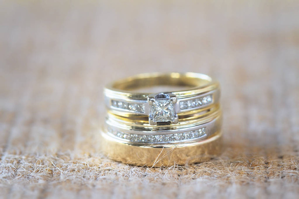 Wedding rings stacked on a textured surface - Photo, Image