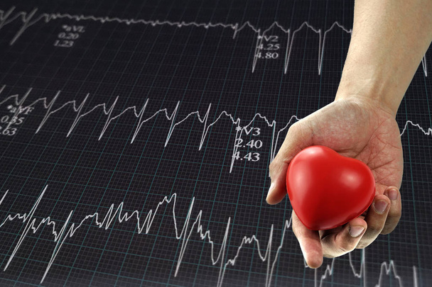 Człowiek w ręku trzymając czerwone serce z wykres bicia serca. Oznaką bólu, cierpi na ból w klatce piersiowej, zawału serca lub bolesne skurcze, naciskając na klatce piersiowej z bolesne wyrażenie. - Zdjęcie, obraz