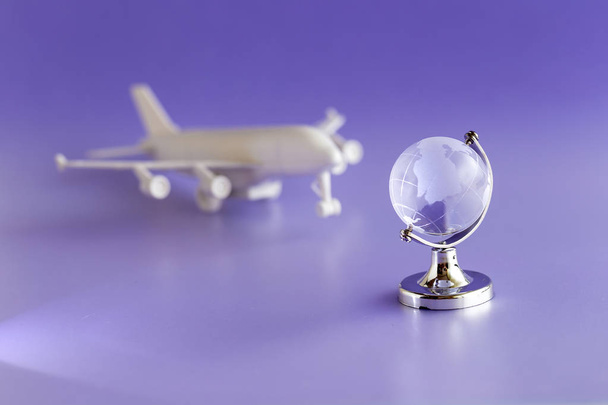 Glas globe en vliegtuig model, reizen en globalisering concept. - Foto, afbeelding