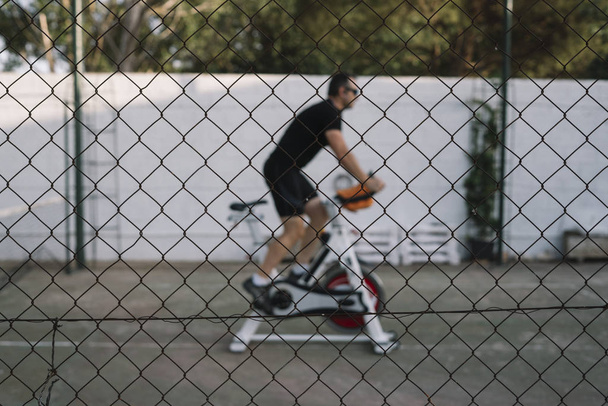 Człowiek, który wykonuje aktywności fizycznej z zewnątrz statyczne rowerów - Zdjęcie, obraz