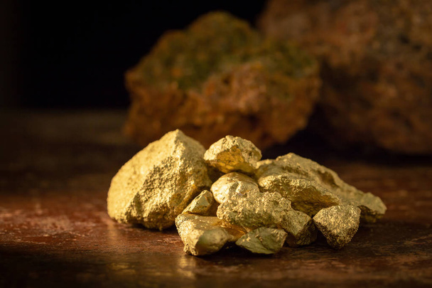 Gold nugget grains on a wooden table. - Foto, immagini