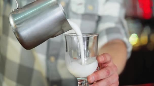 Barista pours milk into a glass. - Materiał filmowy, wideo