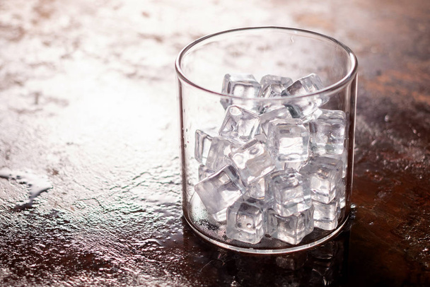 Склянка кубиків льоду на дерев'яному столі
 - Фото, зображення