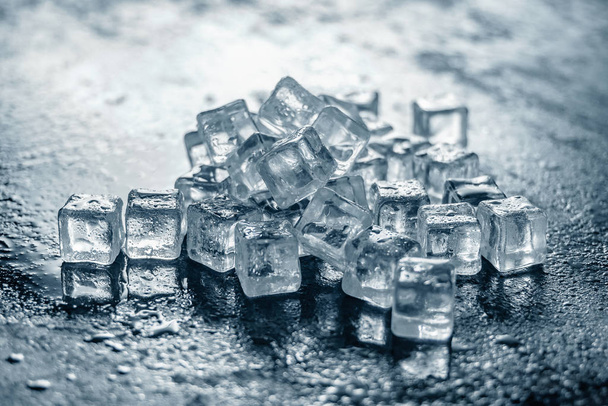 Pile of Ice cubes on dark wooden table - Photo, Image