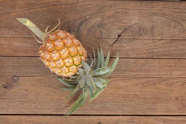 Top view of ripe pineapple on wooden background - Photo, Image