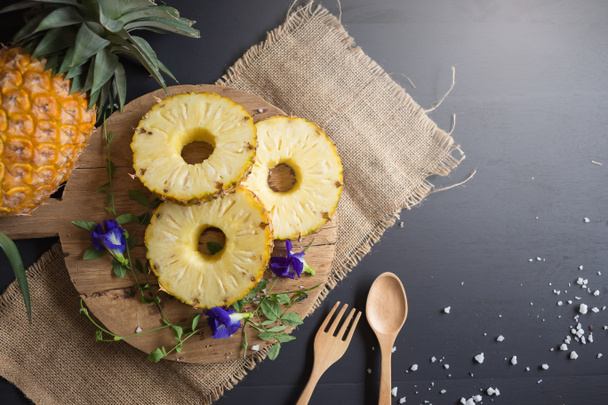 Свіжий жовтий органічний ананас нарізаний скибочками на дерев'яному столі
. - Фото, зображення