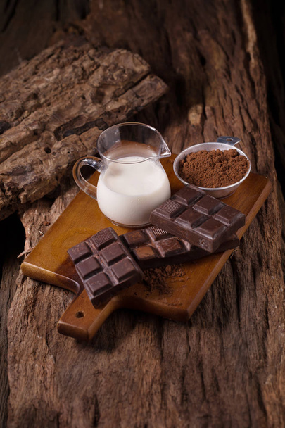Шоколад и молоко на деревянном фоне
. - Фото, изображение