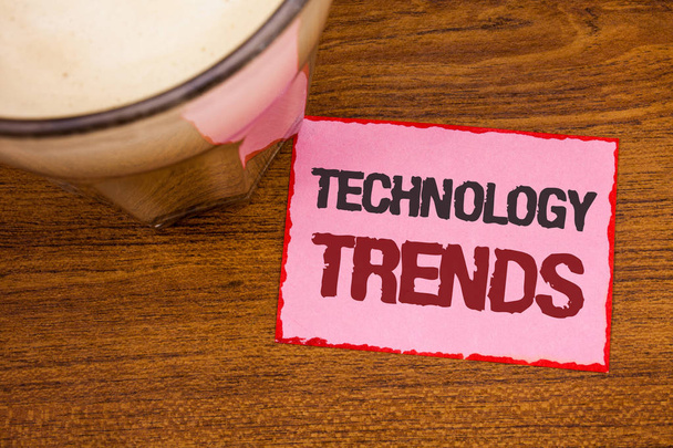 Conceptual hand writing showing Technology Trends. Business photo text Trending Modern Viral Advanced Development Trendy New Wooden desktop red lined pink paper with several texts coffee mug - Photo, Image