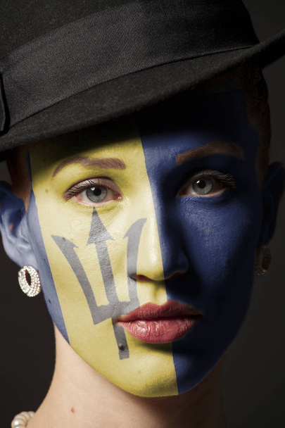 Woman face with painted flag of Barbados closeup on black background - Foto, Imagen