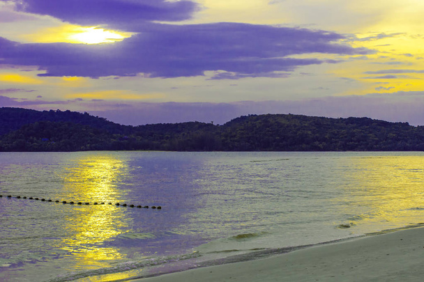 De ondergaande zon schijnt in een bewolkte hemelachtergrond op zee, Azië, eiland Langkawi, Maleisië - Foto, afbeelding