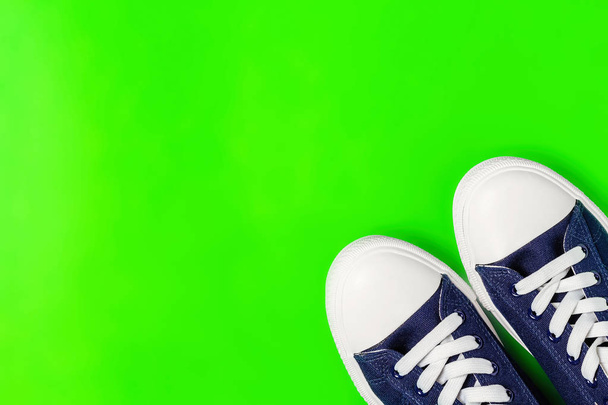 New sneakers on a bright green background. Top view. Copy space - Photo, Image