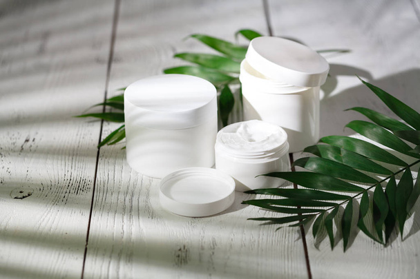 Cosmetic bottle containers with green herbal leaves - Foto, Imagem
