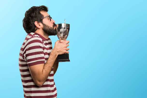 Uomo felice con gli occhiali in possesso di un trofeo su sfondo colorato
 - Foto, immagini