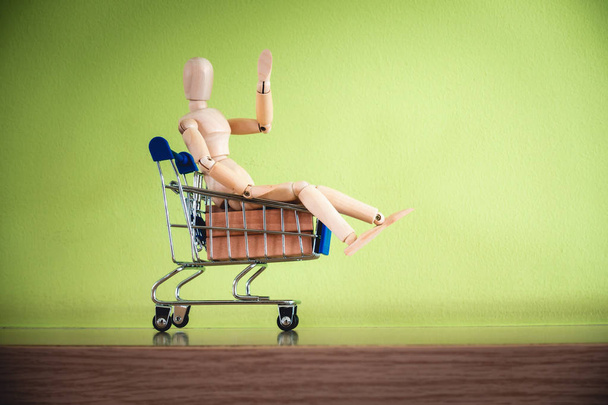Shopping concept., Mini human model is sitting in trolley basket. - Fotoğraf, Görsel