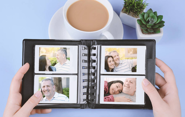 Photo album with instant photos of middle age couple on light blue background. Memories concept - Photo, Image
