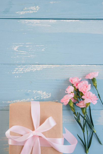 Valentines day. Gift box and flowers on blue background top view - 写真・画像