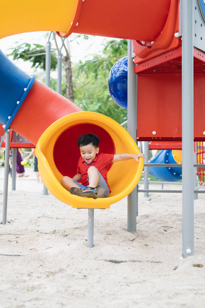 Милий маленький хлопчик розважається на дитячому майданчику на відкритому повітрі влітку
 - Фото, зображення