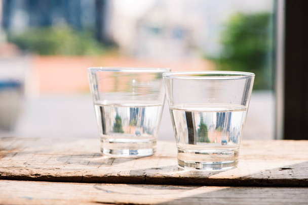 İki bardak su ahşap arka plan üzerinde masada - Fotoğraf, Görsel