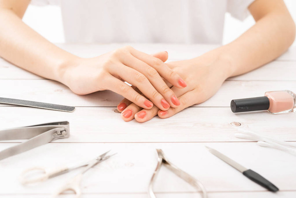 Nagelverzorging en manicure. Prachtige vrouwelijke handen met nagellak. Rode manicure - Foto, afbeelding