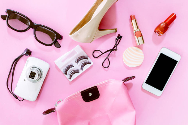 Accesorios y zapatos femeninos con set cosmético sobre fondo rosa
 - Foto, Imagen