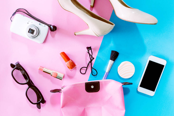 weibliche Accessoires und Schuhe mit Kosmetikset auf rosa Hintergrund - Foto, Bild