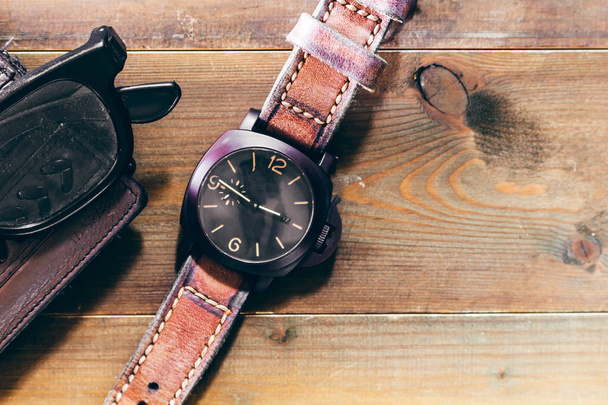 Lederen portemonnee en een horloge op houten achtergrond - Man accessoires - Foto, afbeelding