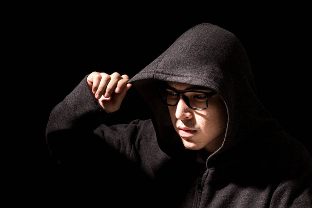 Χάκερ σε μια κουκούλα σε σκούρο φόντο - Φωτογραφία, εικόνα