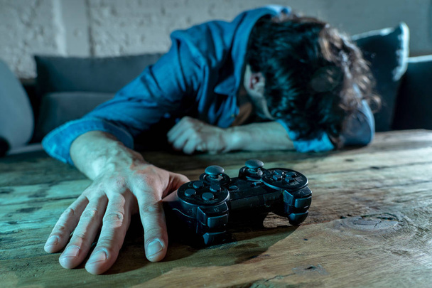 Addiction and dependency concept. close up on young man  with pad joystick playing video games Male addicted to console gaming concept. - Φωτογραφία, εικόνα