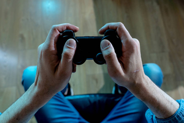 Addiction and dependency concept. close up on young man's hands with pad joystick playing video games. Male addicted to console gaming concept. - Foto, Imagem