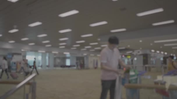 Silhouettes of people at the airport / Silhouette of passengers in the airport carrying bags and luggage trolleys - Footage, Video