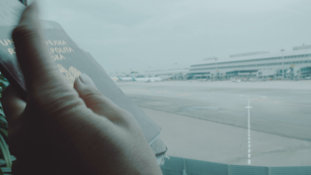 Naisen kädet pitävät passeja lentokentällä / lähikuva naisen käsissä pitäen passeja lentokentällä. Lentoyhtiön matkustaja lentoaseman lounge odottaa lennon ilma
 - Materiaali, video