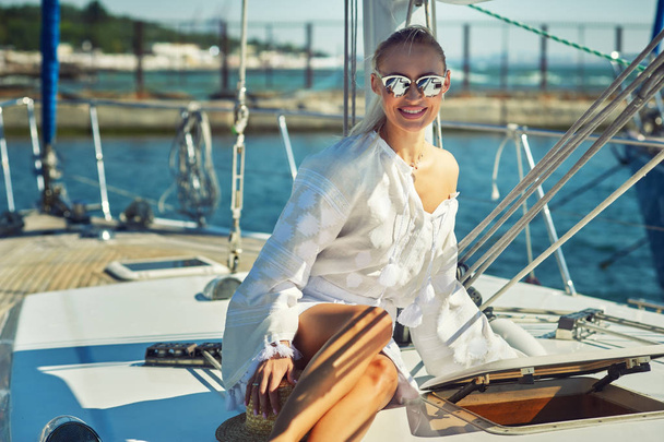 Vonzó fiatal nő egy jachton, egy nyári napon. Gyönyörű divatos nő, nyáron szabadban., fiatal, boldog asszony a háttérben a tengeri hajók. - Fotó, kép
