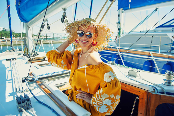 Attractive young woman on a yacht on a summer day. Beautiful fashionable woman in summer outdoors., young happy woman on the background of sea boats. - Photo, Image