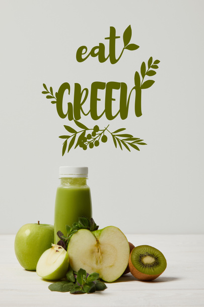 green detox smoothie with apples, kiwi and mint and on white wooden surface, eat green inscription - Photo, Image